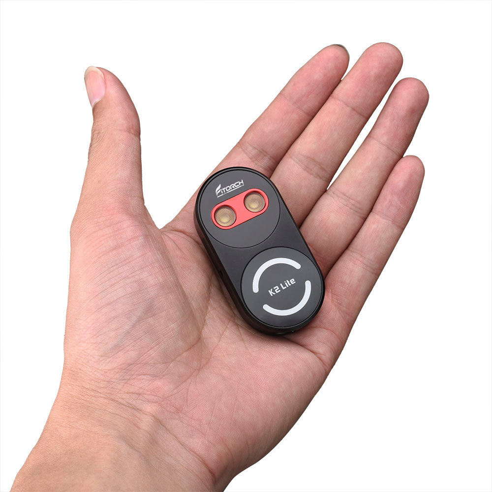 Fitorch K2 Lite black keychain light resting in a palm to show its small size