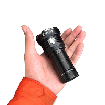 Fitorch P50 black searchlight resting in a palm